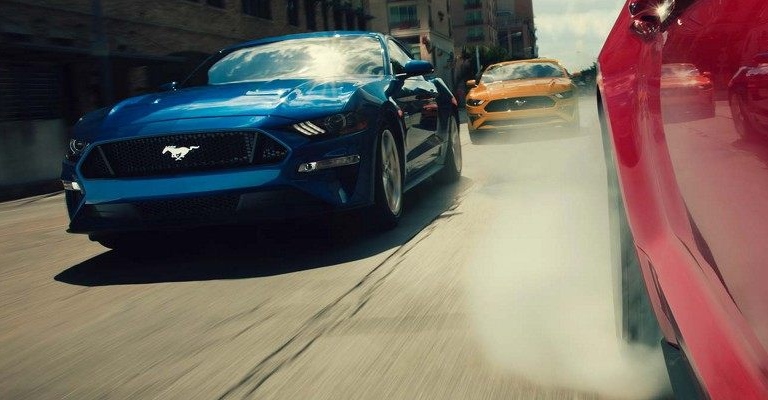 2018 Ford Mustang front view of two models from another model doing a burnout