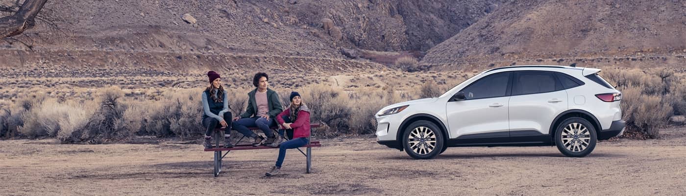 Friends sitting at table next to Ford Escape
